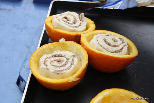 Orange rolls cooked in oranges over a fire