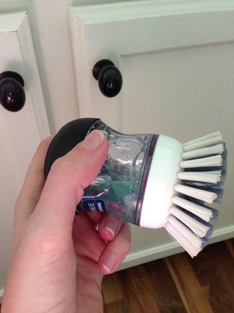 Use a dish scrubber filled with dish soap to clean the gunk off your cabinets